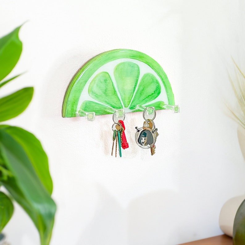 hand-painted lime slice key holder, featuring vibrant green and yellow hues on a wooden base