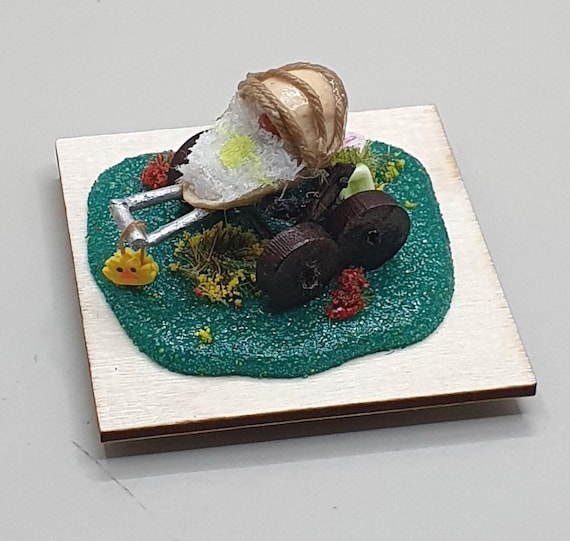A fully working miniature pram built inside a pistachio shell — the kind of insane micro-craft that stops people mid-sentence when they spot it.