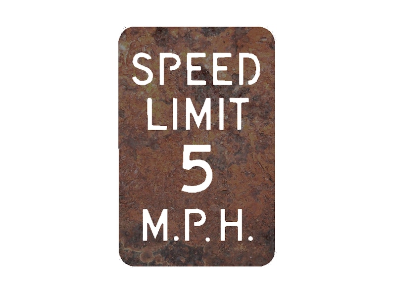 May include: A rusty metal sign with white text that reads "SPEED LIMIT 5 M.P.H."