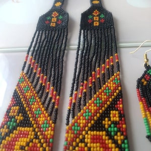 May include: A black beaded necklace and earrings set with a geometric pattern in red, yellow, and green.
