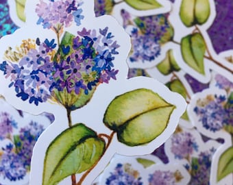 May include: Watercolor stickers featuring lilac flowers with purple and blue blossoms, green leaves, and brown stems. The stickers have a white border and are scattered on a glittery purple surface. The stickers are ideal for scrapbooking and crafts.