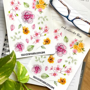 May include: Two sticker sheets featuring watercolor floral designs. The stickers include pink roses, yellow and pink blossoms, and green leaves. One sheet has the text "pink watercolor bliss". The website address stickersbyjodi.etsy.com is printed on the bottom of each sheet.