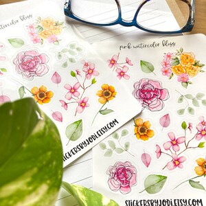 May include: Two sheets of floral stickers with watercolor designs. The stickers feature pink, yellow, and orange flowers, green leaves, and the text "watercolor bliss" and "pink watercolor bliss". The website address stickersbyjodi.etsy.com is also visible.