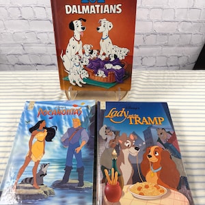 May include: Three vintage Disney storybooks: "101 Dalmatians," "Pocahontas," and "Lady and the Tramp." The "101 Dalmatians" book features a red cover with Dalmatian illustrations. "Pocahontas" has a blue cover with Pocahontas and John Smith. "Lady and the Tramp" has a blue cover.