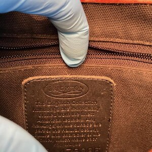 May include: A brown leather tag with the text "The Brighton Collection Handbags are individually crafted from the finest American leathers. Any markings on the surface are part of the natural beauty and character of the leather which will only improve with age." and the number "4179082".