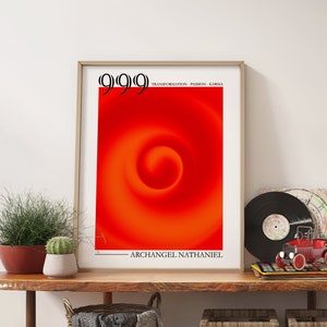 Puede incluir: Un p&oacute;ster enmarcado con un dise&ntilde;o de remolino rojo y naranja y el texto "9999" y "ARCHANGEL NATHANIEL". El p&oacute;ster est&aacute; en un estante de madera con dos cestas de mimbre, un disco y un coche de juguete.