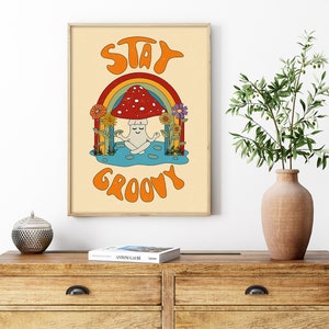 May include: A retro-style poster with a mushroom meditating under a rainbow. The poster has the text "Stay Groovy" in orange letters.