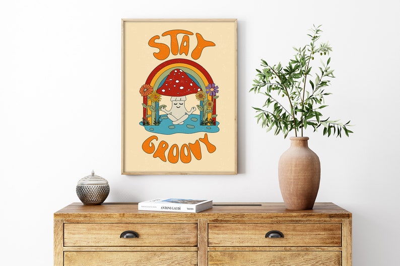 May include: A retro-style poster with a mushroom meditating under a rainbow. The poster has the text "Stay Groovy" in orange letters.