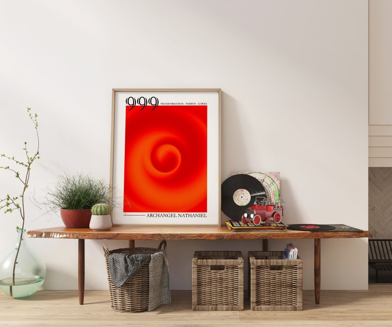 Puede incluir: Un p&oacute;ster enmarcado con un dise&ntilde;o de remolino rojo y naranja y el texto "9999" y "ARCHANGEL NATHANIEL". El p&oacute;ster est&aacute; en un estante de madera con dos cestas de mimbre, un disco y un coche de juguete.