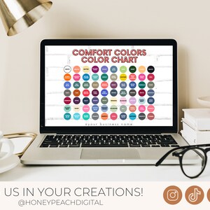 May include: A laptop screen displaying a colour chart with the title "Comfort Colors Colour Chart". The chart shows a grid of 100 small circles, each representing a different colour. The text "@your business name" is at the bottom of the chart.