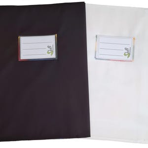 May include: Two rectangular fabric pouches, one black and one white, each featuring a stitched-on white label with three horizontal lines for writing and the text "taffi" in green with a small logo, finished with colorful zigzag stitching.