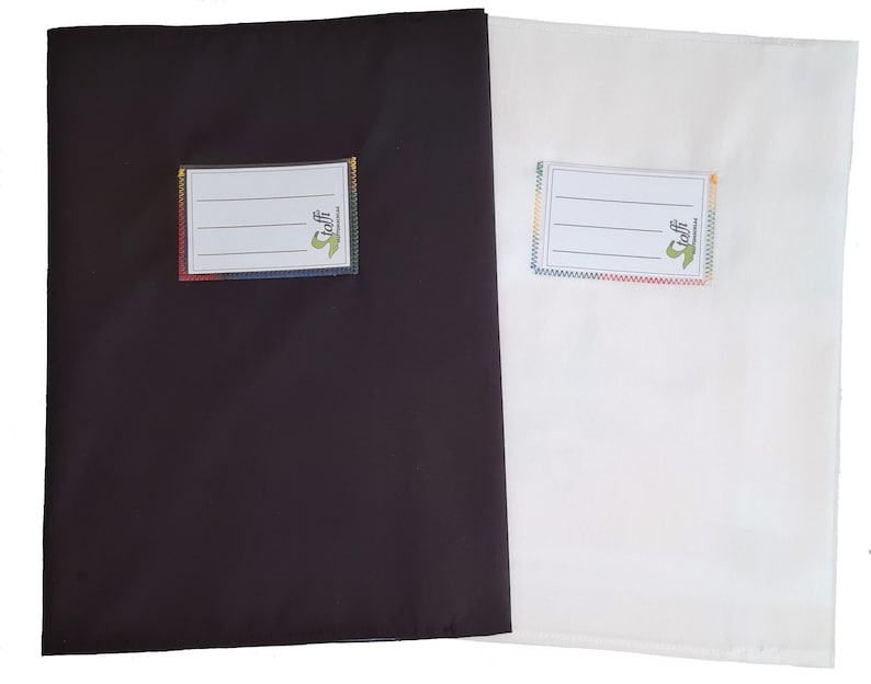 May include: Two rectangular fabric pouches, one black and one white, each featuring a stitched-on white label with three horizontal lines for writing and the text "taffi" in green with a small logo, finished with colorful zigzag stitching.