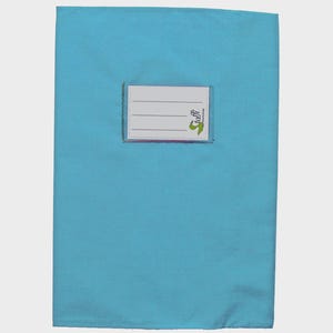 May include: A rectangular light blue fabric book cover featuring a centered white rectangular label with three horizontal lines for writing. The label includes the green text "Stoffi" and a small green graphic icon on the right side.