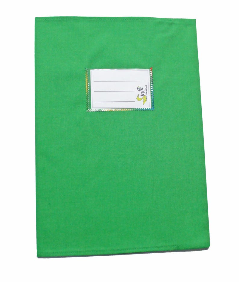 May include: A bright green rectangular fabric book cover featuring a white rectangular label with three horizontal lines for writing and the text "toffi" printed in yellow and black. The label is bordered by a thin, iridescent, multi-colored trim.
