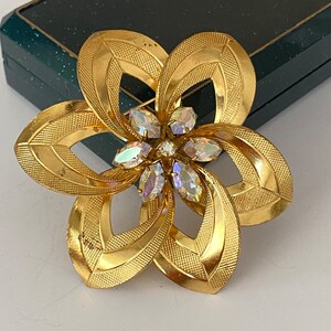 Vintage gold/brass tone filigree flower brooch/pin with purple stoun
