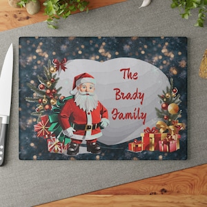 Personalized Christmas Glass Cutting Board with Santa Claus over a Frosted snowflake pattern with a Heart and your family name serving board