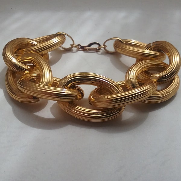 Thick golden bracelet made of recycled chain with striped relief. Eighties design
