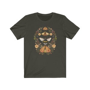 K&ouml;nnte beinhalten: Ein dunkelgr&uuml;nes T-Shirt mit einem floralen Design mit einer Biene und drei Motten. Das Design ist in den Farben Gelb, Orange, Braun und Wei&szlig; gehalten.