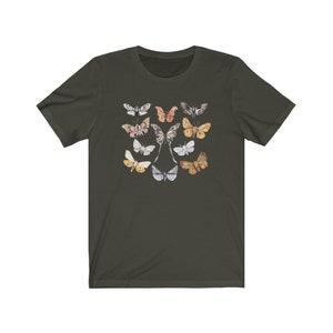 May include: Dark green t-shirt featuring a collection of watercolor-style butterfly illustrations in various colors. The butterflies are arranged in a symmetrical pattern, showcasing their intricate wing designs. The shirt is made of a soft material.