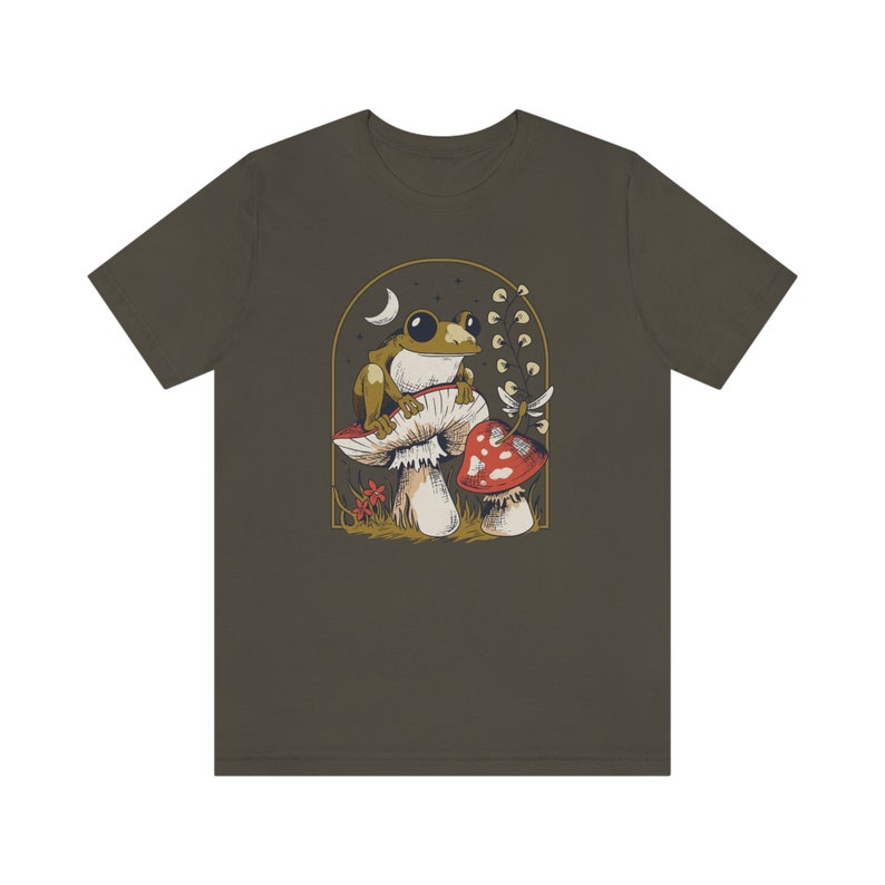 May include: A dark green t-shirt with a graphic of a frog sitting on a mushroom with a smaller mushroom next to it. The graphic is surrounded by a gold frame and has a crescent moon in the background.