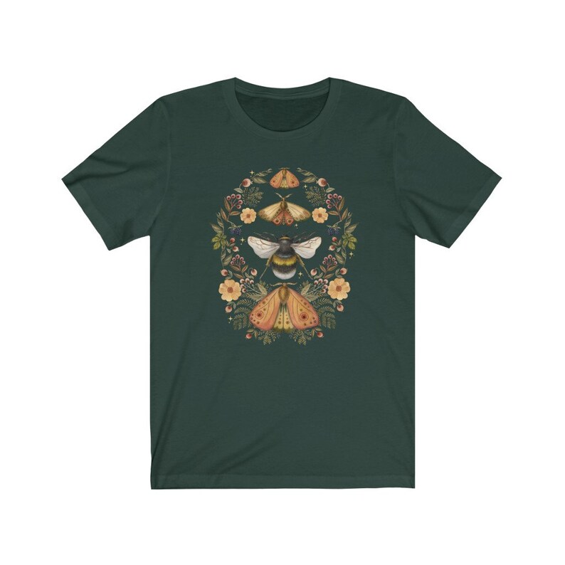 K&ouml;nnte beinhalten: Ein dunkelgr&uuml;nes T-Shirt mit einem kreisf&ouml;rmigen Design, das eine Biene und zwei Motten zeigt, die von Blumen und Bl&auml;ttern umgeben sind.