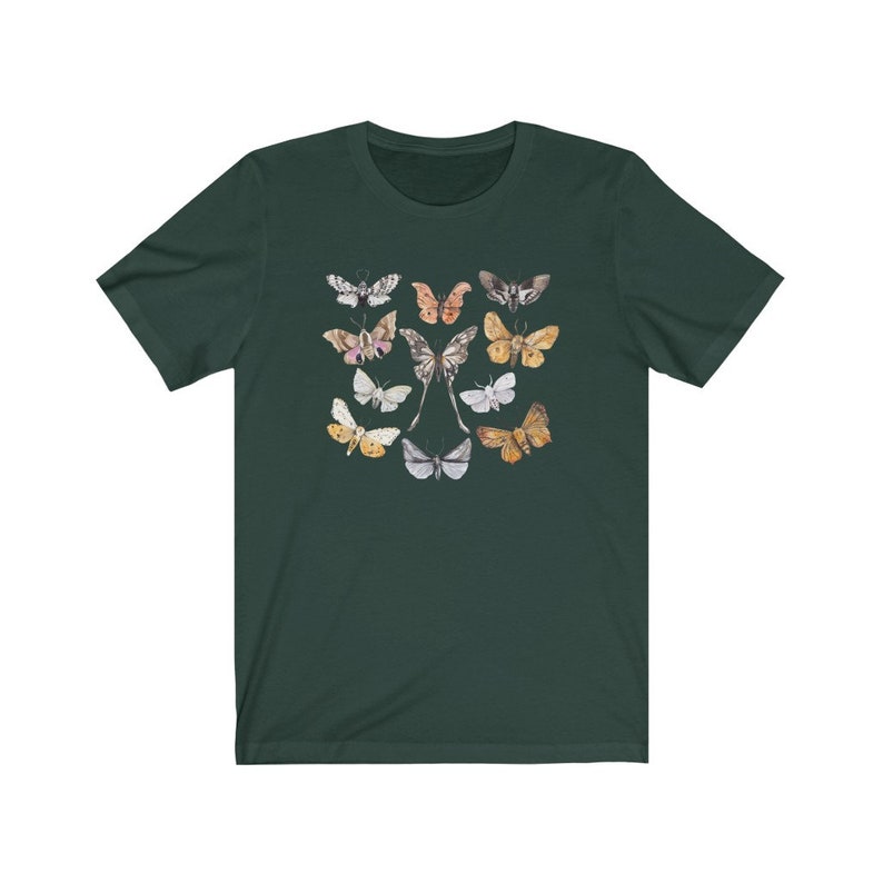 May include: Dark green t-shirt featuring a collection of watercolor butterflies in various colors. The butterflies are arranged in a symmetrical pattern, with a central pair and surrounding insects in shades of pink, yellow, and gray.