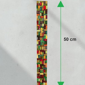 Puede incluir: Una obra de arte en mosaico rectangular, de 6 cm de ancho y 50 cm de largo, compuesta por pequeñas baldosas de forma irregular en tonos rojos, verdes, amarillos y marrones. La obra se muestra verticalmente.