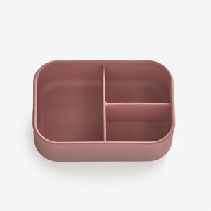 May include: A pink silicone divided container with three sections. The container is empty.