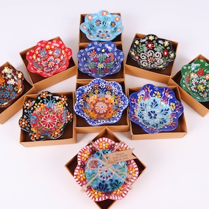 Op de afbeelding: Assortiment van kleine, handbeschilderde keramische kommen met bloemmotieven in verschillende kleuren. De kommen worden gepresenteerd in individuele dozen met een label waarop "Noah's First Communion July 26, 2019" staat.