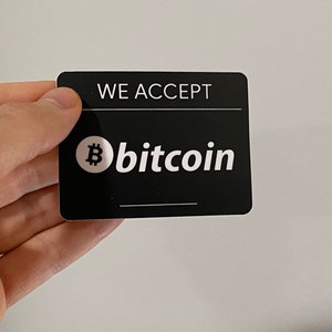 May include: Black and white sticker with the text "WE ACCEPT bitcoin" and a bitcoin symbol.