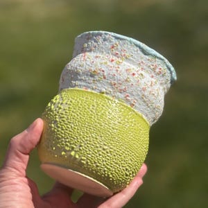 May include: A handmade, wooden cutting board with a natural finish. The board features a live edge on one side and a smooth, rectangular shape. It is approximately 18 inches long and 12 inches wide.