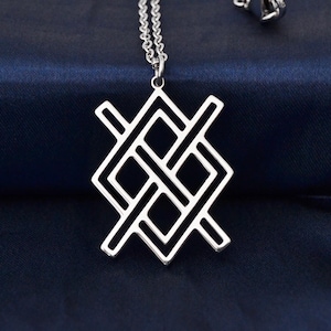 May include: A silver pendant necklace with a geometric design. The pendant has an openwork pattern of intersecting lines and shapes. The necklace chain is silver and hangs against a dark blue background.