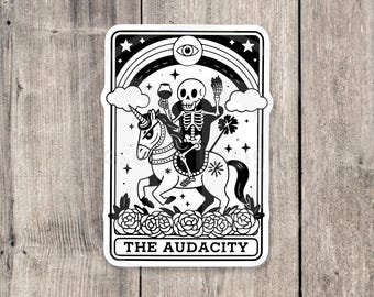 May include: Black and white illustration of a skeleton riding a unicorn. The skeleton is holding a glass of wine and a broom. The unicorn is surrounded by roses. The text "THE AUDACITY" is at the bottom of the image.