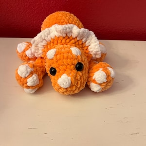 Handmade crochet laying triceratops