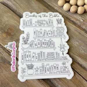 May include: A white die-cut sticker featuring a black line drawing of a bookshelf with the text Books of the Bible, organized into five shelves containing labeled book spines and potted plants, alongside a smaller vertical sticker with pink text.