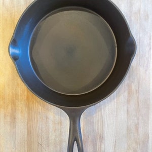 May include: A black cast iron skillet with a long handle. The skillet is empty and has a smooth, dark surface.