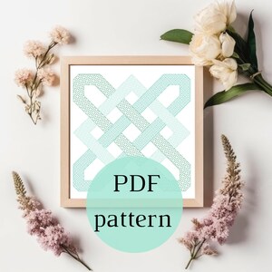 Op de afbeelding: Een ingelijst afdruk van een geometrisch patroon in tinten blauw en groen. De afdruk is omgeven door een licht houten frame. De tekst "PDF pattern" staat op een lichtblauwe cirkel voor het frame.