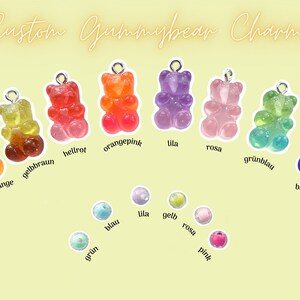 May include: Assortment of gummy bear charms in various colors, including orange, pink, green, blue, and yellow. The charms are displayed on a light yellow background with the text "Custom Gummybear Charms" and "The possibilities are endless".