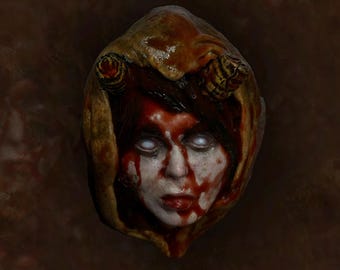 May include: A bloody, pale face with white eyes is encased in a brown, fleshy material. The face is covered in blood and has a distressed expression.