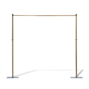 This sleek, minimalist structure is a gold-toned metal frame (likely an event backdrop stand) with two tall vertical poles, a horizontal top bar, and square base plates for stability. The polished brass-like finish gives it a modern, elegant look, while adjustable joints (visible on the poles) suggest versatility for different setups. Set against a plain white background, it appears lightweight yet sturdy—ideal for supporting backdrops, drapes, or decor at weddings, parties, or other events.
