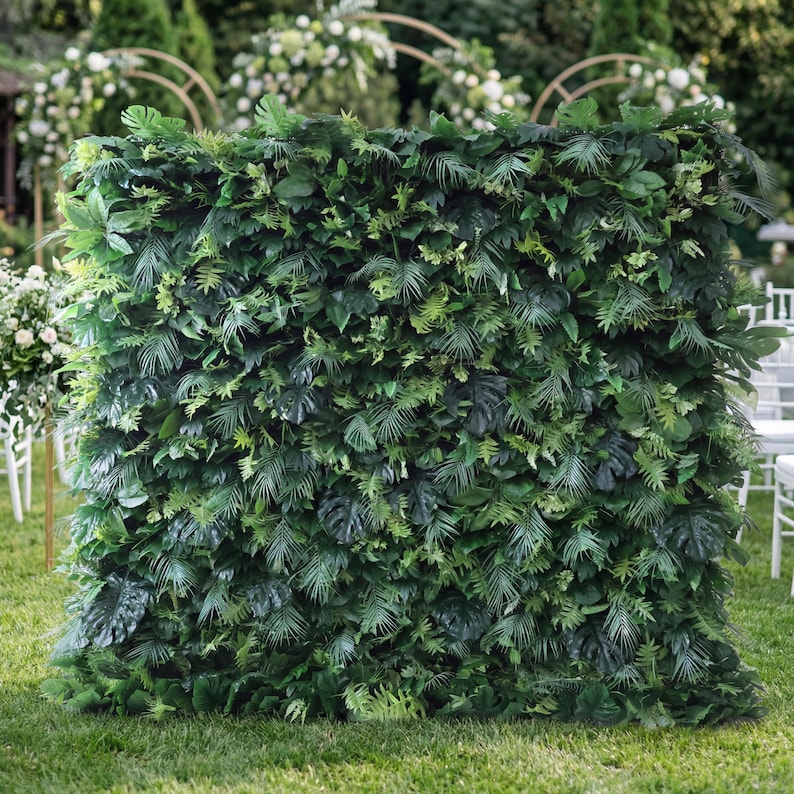 Valar Flowers premium artificial tropical greenery wall backdrop, dense with lifelike monstera leaves, palm fronds, and ferns in vibrant green tones. Perfect for outdoor weddings, event decor, photo booths, privacy screening, and garden styling, this UV-resistant foliage wall delivers a lush, jungle-inspired aesthetic.