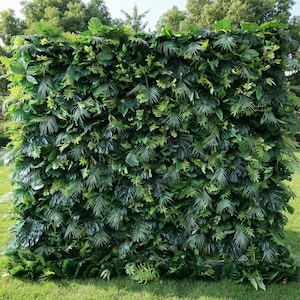 Premium artificial tropical greenery wall backdrop, dense with lifelike monstera leaves, palm fronds, and ferns in vibrant green tones. Perfect for outdoor weddings, event decor, photo booths, privacy screening, and garden styling, this UV-resistant foliage wall delivers a lush, jungle-inspired aesthetic.