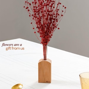 Lebendiges Dekor mit Holzpflanzer und roten Trockenblumen