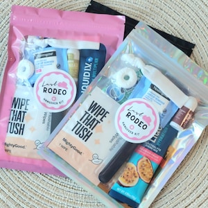May include: Two clear, iridescent zipper pouches filled with hangover kit items. Each kit includes a round sticker that says "Last Rodeo Hangover Kit". The kits contain wipes, makeup remover, and electrolyte drink mix.