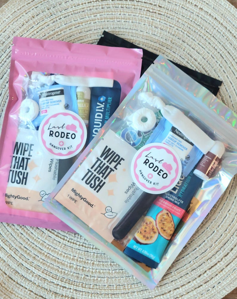 May include: Two clear, iridescent zipper pouches filled with hangover kit items. Each kit includes a round sticker that says "Last Rodeo Hangover Kit". The kits contain wipes, makeup remover, and electrolyte drink mix.