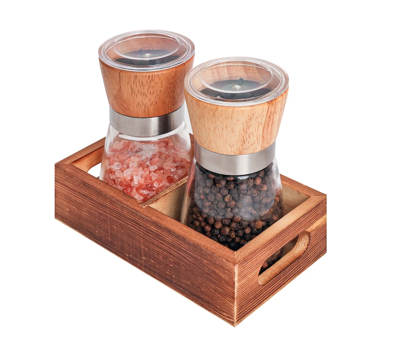 Peut inclure: Un plateau en bois contient deux moulins &agrave; sel et &agrave; poivre en verre. L'un contient du sel rose de l'Himalaya, l'autre des grains de poivre noir. Les deux ont des couvercles en bois et des bandes en acier inoxydable. Le plateau est en bois teint&eacute;.