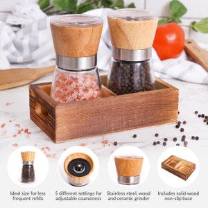 Peut inclure: Un ensemble de moulins &agrave; sel et &agrave; poivre en bois avec une base en bois. Un moulin contient du sel rose, l'autre des grains de poivre noir. Les moulins ont des corps en verre, des accents en acier inoxydable et des dessus en bois. L'ensemble comprend une base en bois massif antid&eacute;rapante.