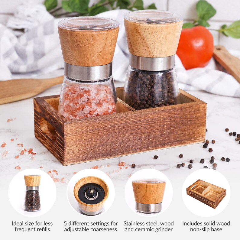 Peut inclure: Un ensemble de moulins &agrave; sel et &agrave; poivre en bois avec une base en bois. Un moulin contient du sel rose, l'autre des grains de poivre noir. Les moulins ont des corps en verre, des accents en acier inoxydable et des dessus en bois. L'ensemble comprend une base en bois massif antid&eacute;rapante.