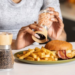Peut inclure: Un moulin &agrave; sel en verre avec un dessus en bois est utilis&eacute; pour assaisonner un hamburger et des frites sur une assiette verte. Le burger contient du bacon et du fromage. Un moulin &agrave; poivre est &agrave; proximit&eacute;.