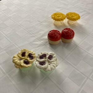 May include: Set of six vintage ceramic salt and pepper shakers with floral designs. Two yellow flower shakers, two red flower shakers, and two pansy shakers, one yellow and one white.